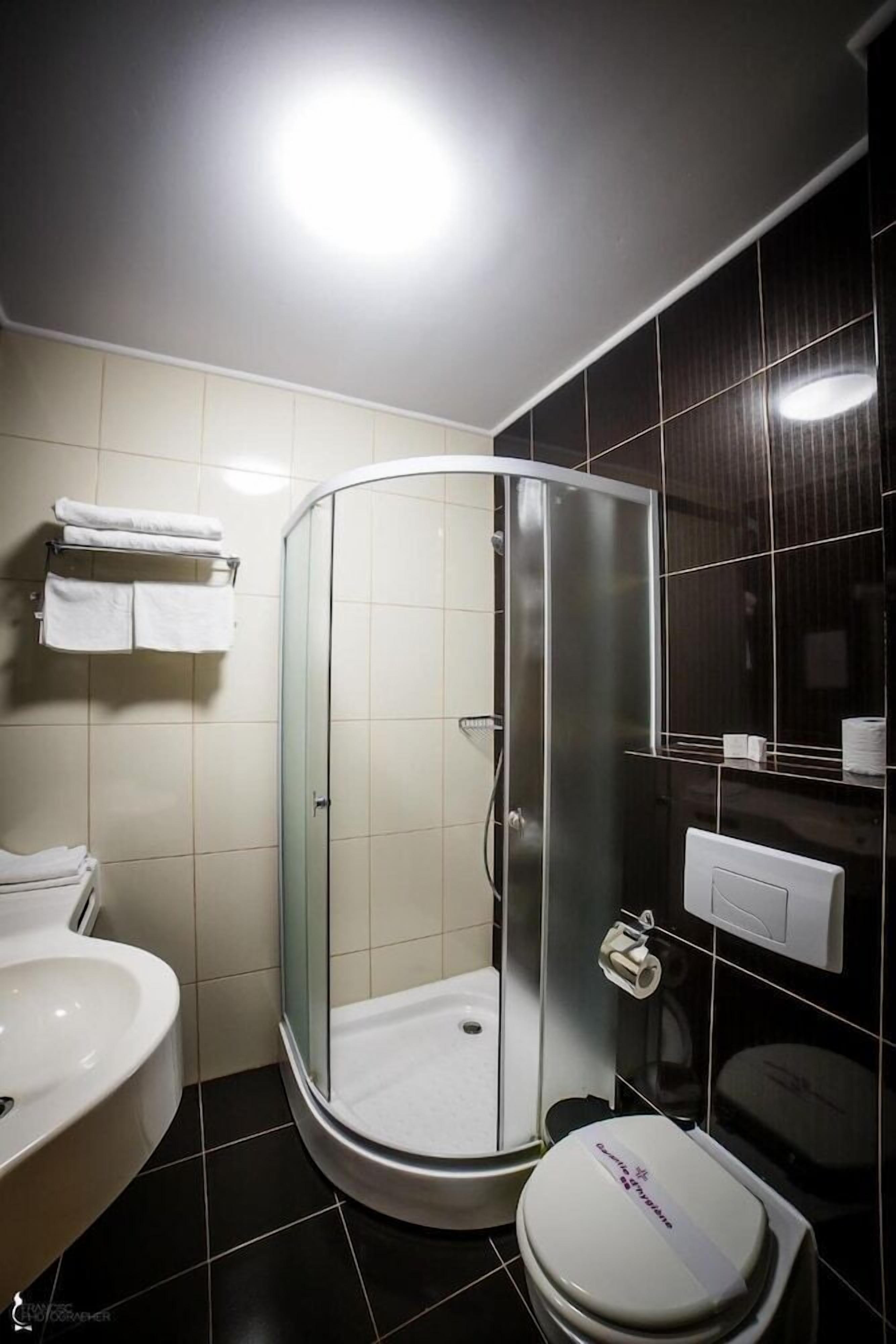 Un baño moderno con ducha de vidrio, inodoro y lavamanos.