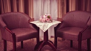 Two striped armchairs with a table between them, a floral centerpiece, and a patterned carpet. - Ozana (Bistri?a)