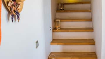 Eine Treppe mit Holzstufen, ein Hut an der Wand und Laternen auf jeder Stufe.