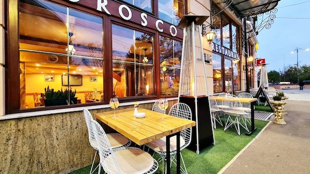 A restaurant named 'HOSCO' with outdoor seating and a view of the interior.