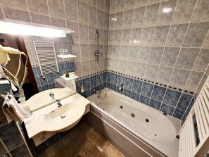 A bathroom with a bathtub, a sink, and a mirror.