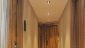 A hallway with wooden doors and a wooden floor. - Elements Rooms and Apartments (Chalandri)