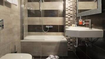 A modern bathroom with a bathtub, toilet, and sink.