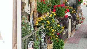A wooden porch with flower planters, a wicker basket, and a bench.