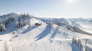 A snow-covered ski slope with a ski lift and a mountain backdrop. - Pension Forsthof (Sankt Johann im Pongau)