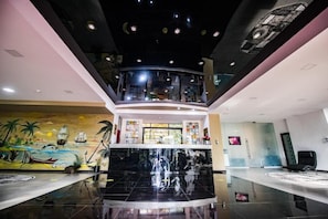 A lobby with a central staircase, a mural, and a reception desk. - Hotel Siret Mamaia (Constanta)