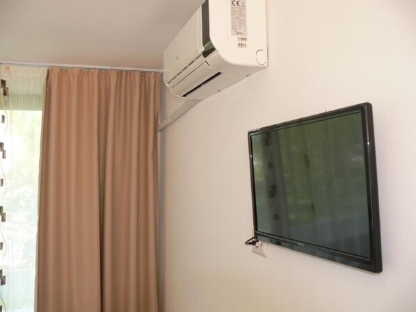 A room with a beige curtain, a mounted air conditioner, and a black-framed window. - Hotel Siret Mamaia (Constanta)