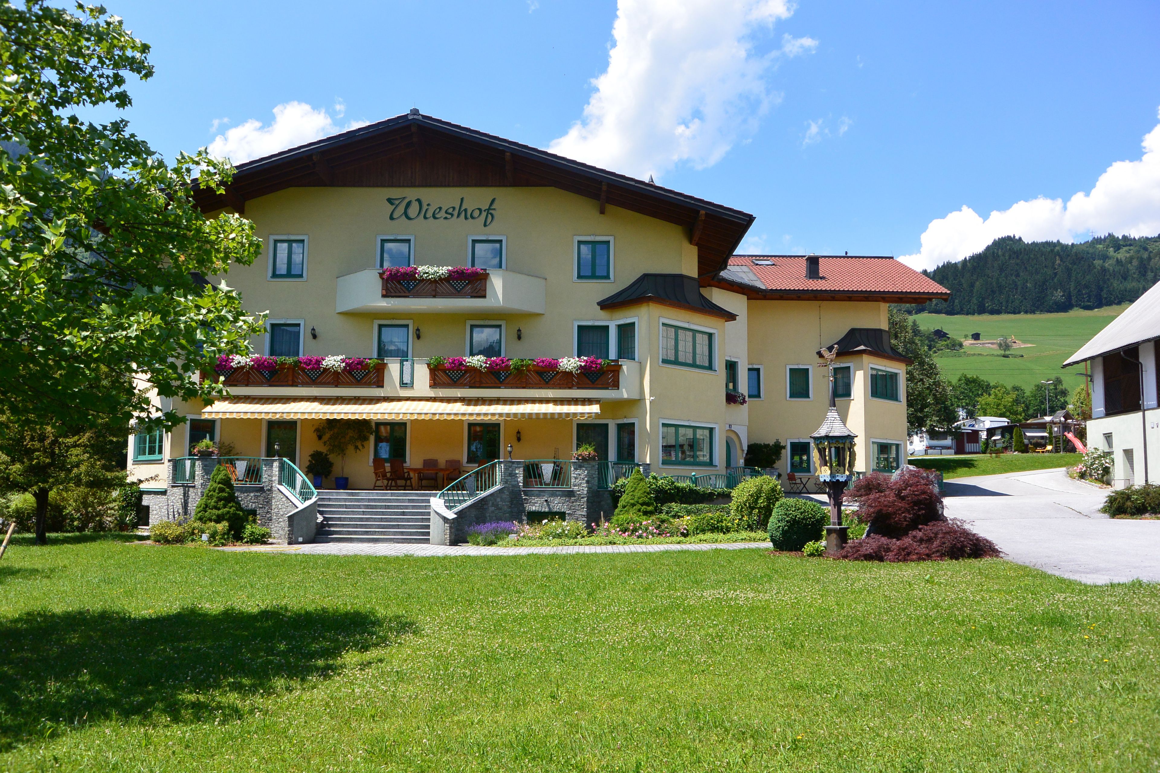 A two-story building with a yellow facade and the name "Wieshof" on the upper level.