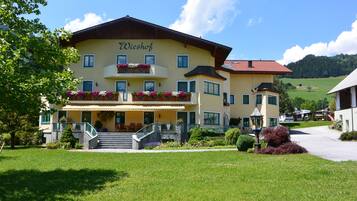 A two-story building with a yellow facade and the name "Wieshof" on the upper level.