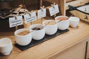 Un buffet avec des plats variés présentés dans des récipients étiquetés.