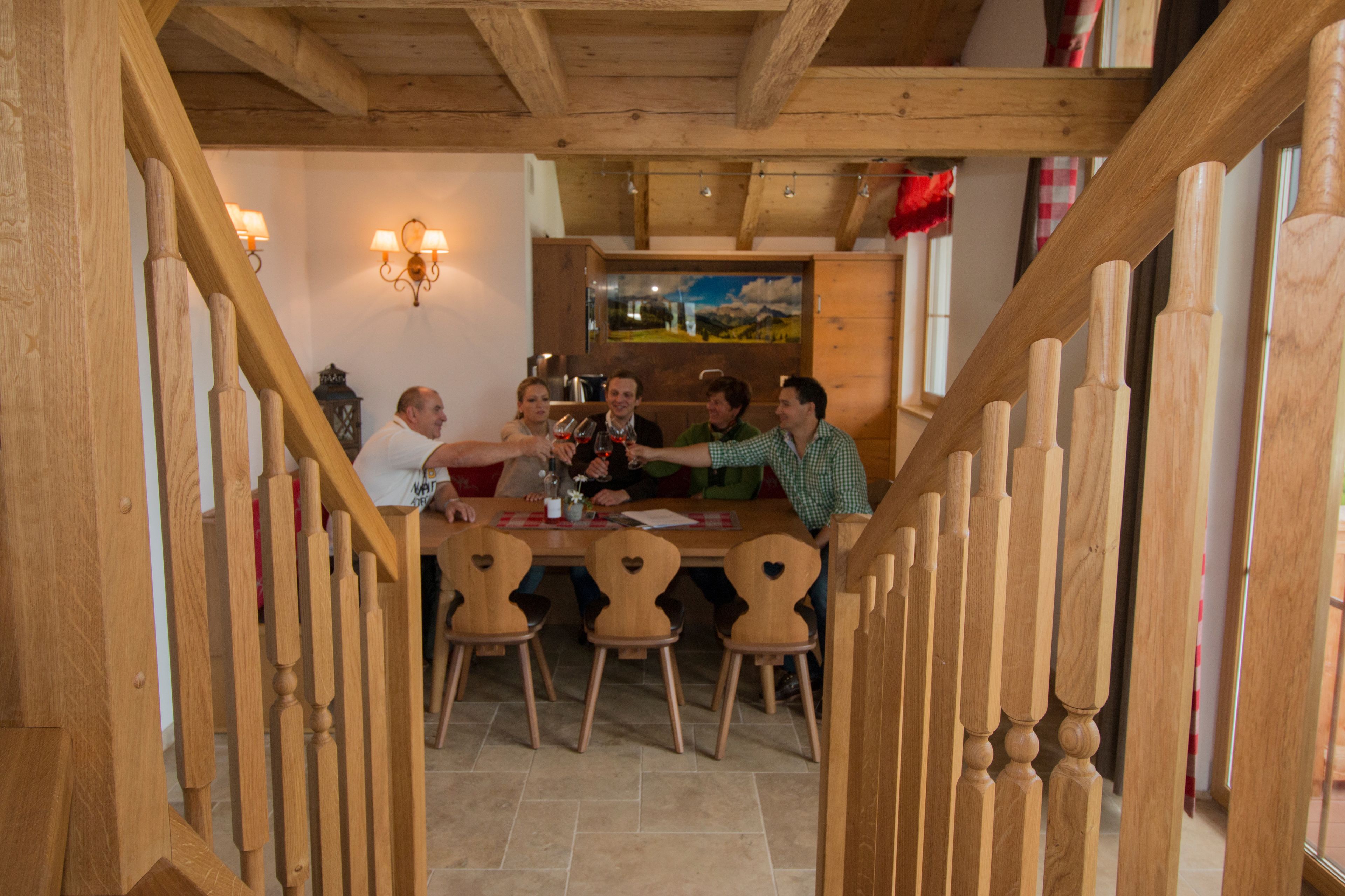 A wooden staircase leading to a dining area with a table and chairs.