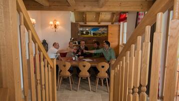 A wooden staircase leading to a dining area with a table and chairs.