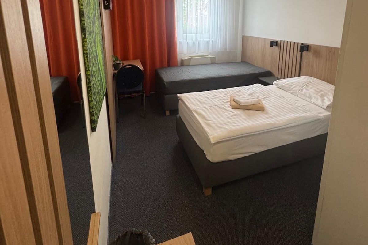 A hotel room with a bed, a desk, and a chair.