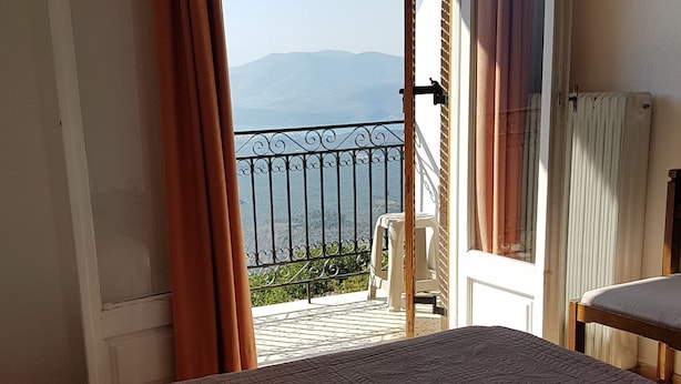 Un dormitorio con una cama, vistas a un balcón y una silla afuera.