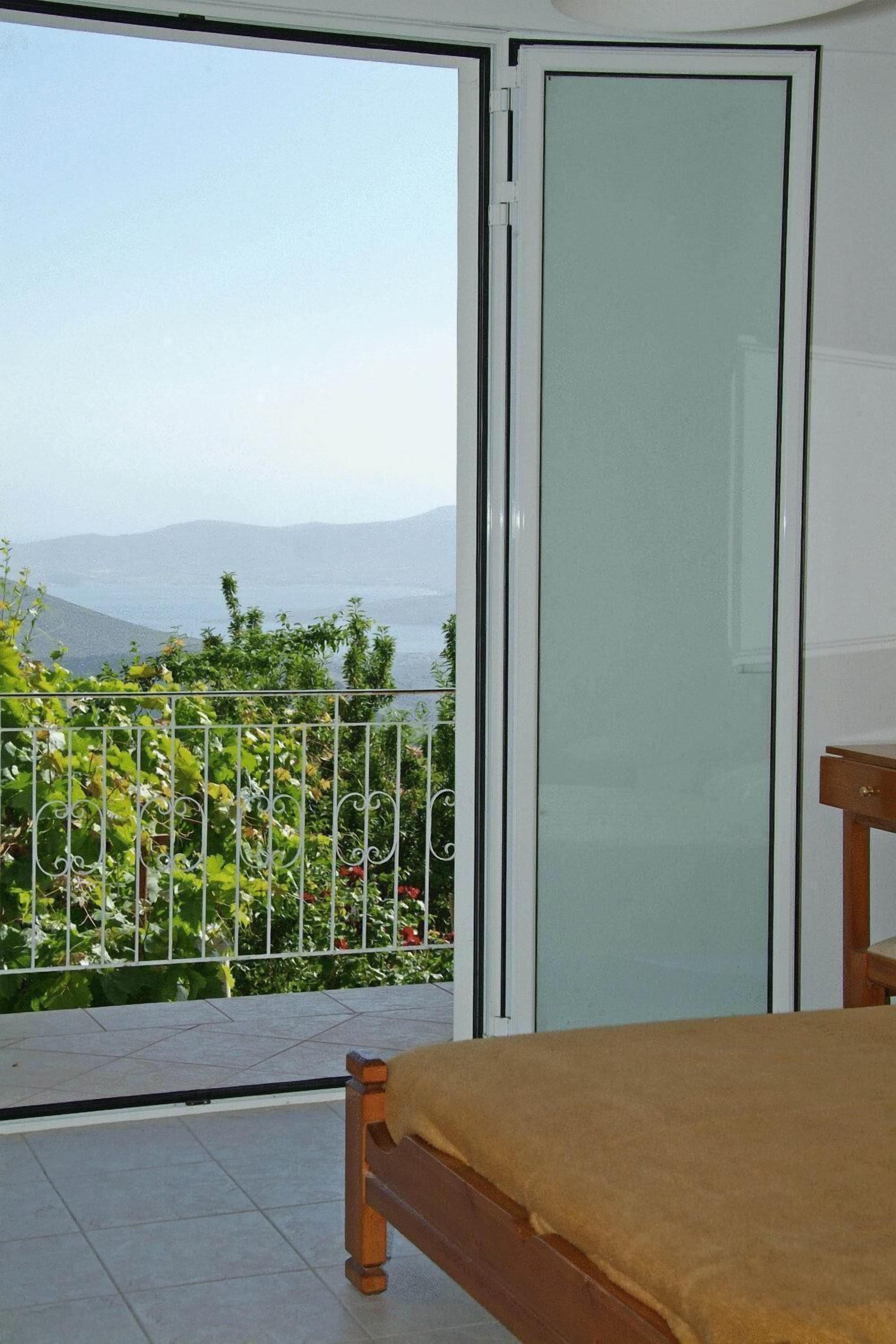 A balcony with a view of mountains and greenery.