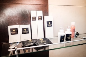 Une salle de bain équipée de produits de toilette et dotée d’une douche en verre.