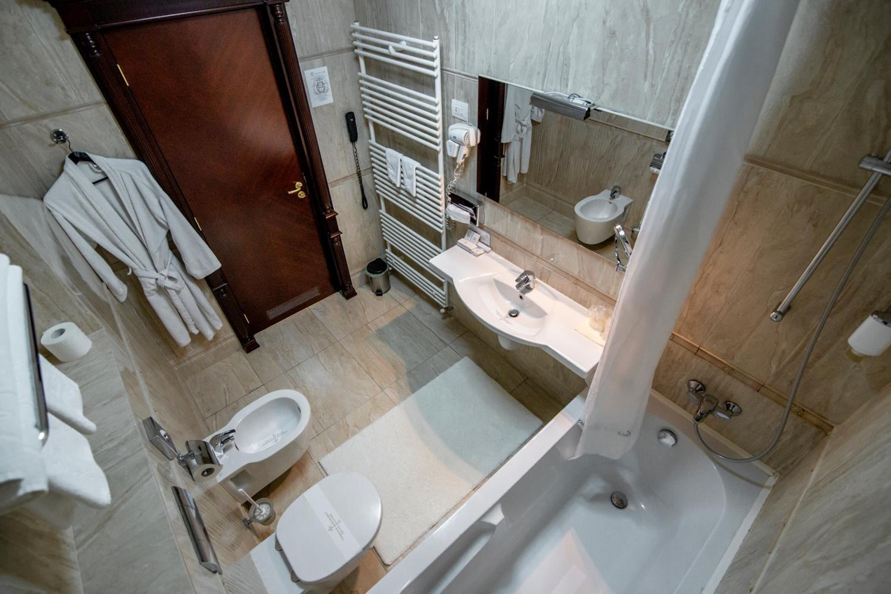 A modern bathroom with a bathtub, a sink, a toilet, and a shower area.