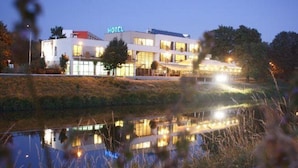 Un hotel con una piscina reflectante al frente.