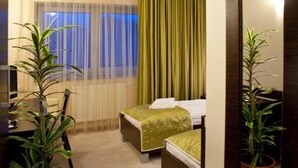 Una habitación de hotel con cama, escritorio y dos plantas en macetas.