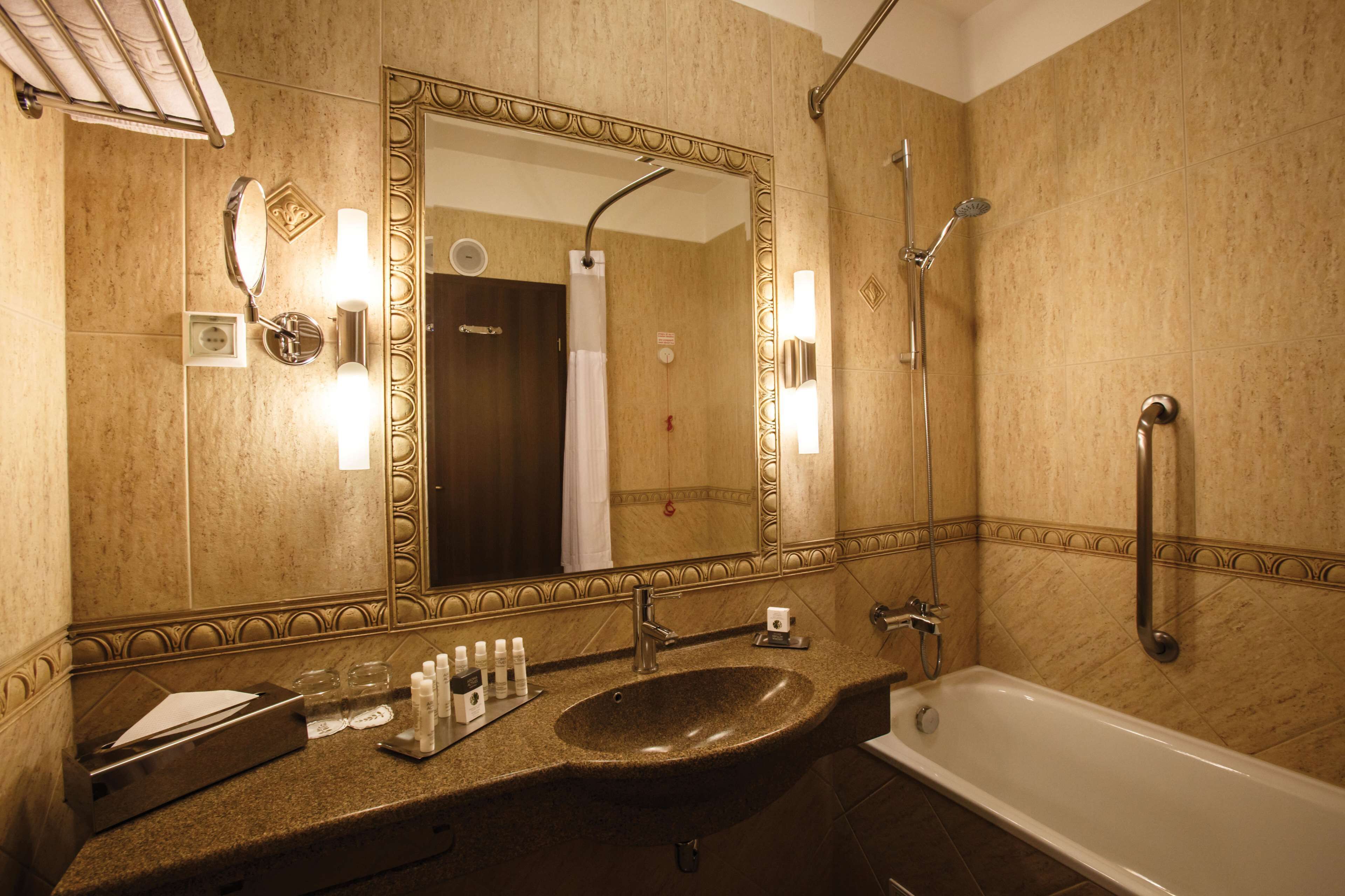 Un baño con lavamanos, espejo y bañera.