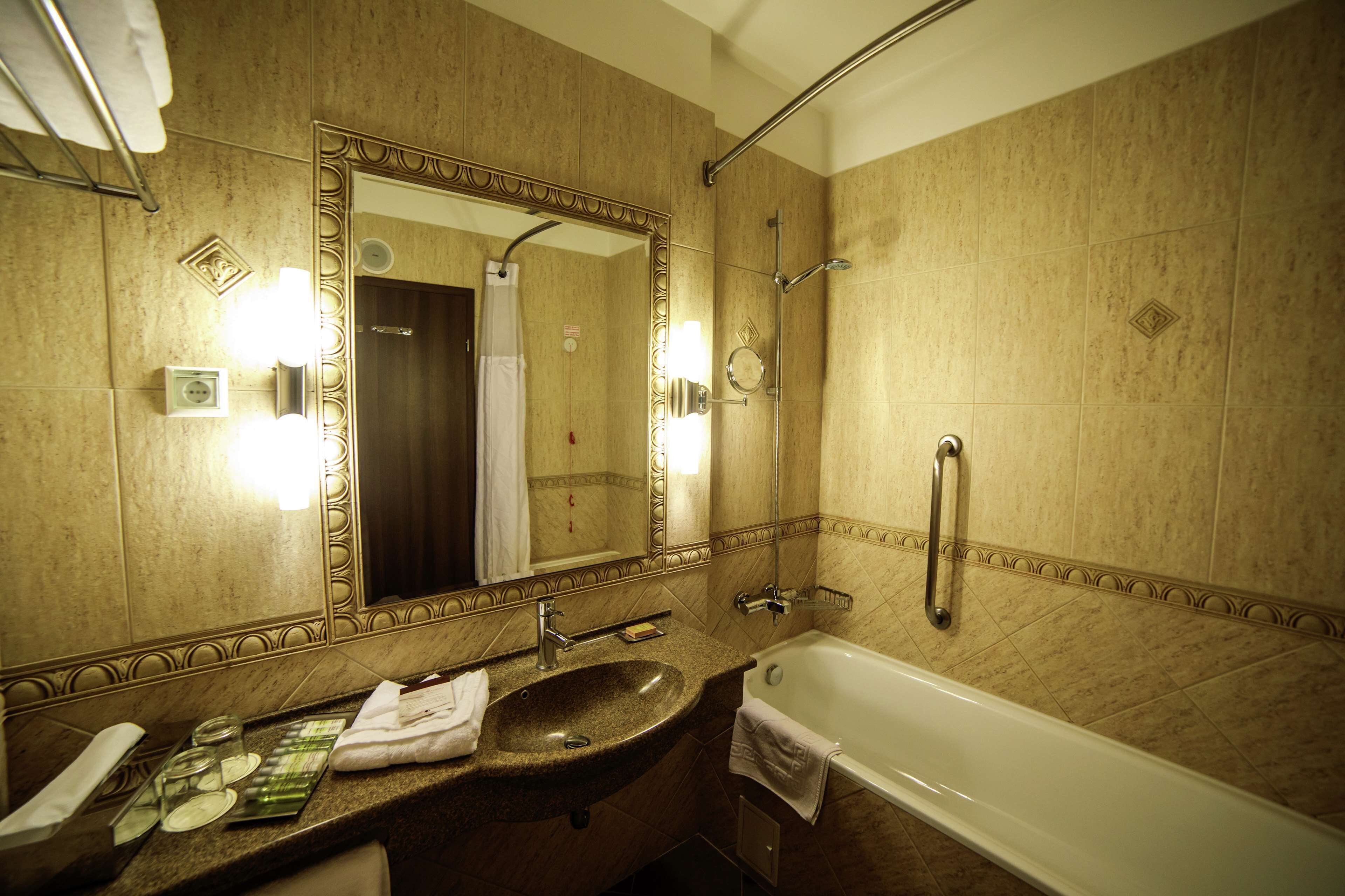 A bathroom with a sink, mirror, and bathtub.