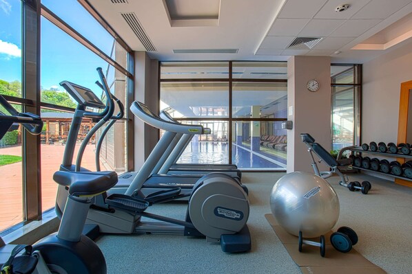 A gym with treadmills, an exercise ball, and dumbbells.