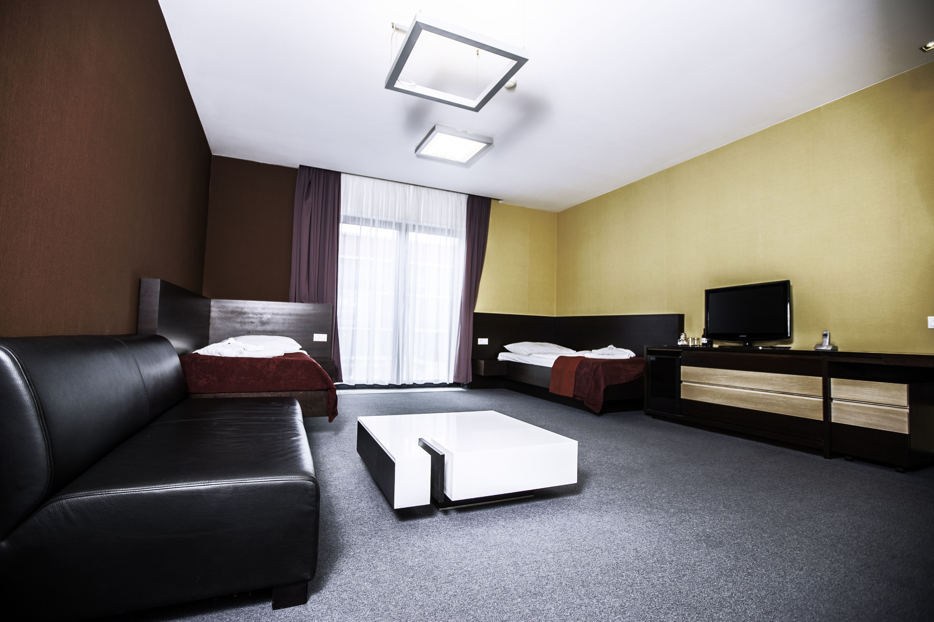 Una habitación de hotel con sofá, cama, escritorio y televisión.