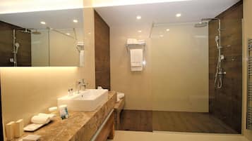 A modern bathroom with a large sink, mirror, and separate shower area.