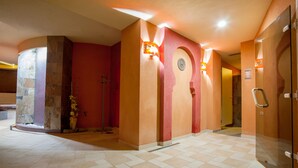 Un hall d’hôtel comprenant un comptoir d’enregistrement, un bureau d’accueil et un ascenseur en verre.