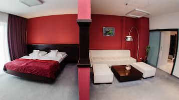 Una habitación de hotel moderna con una cama grande, un sofá blanco y una pequeña mesa.
