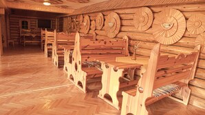 Interior de madeira com um longo banco, decoração de parede em madeira e lareira.