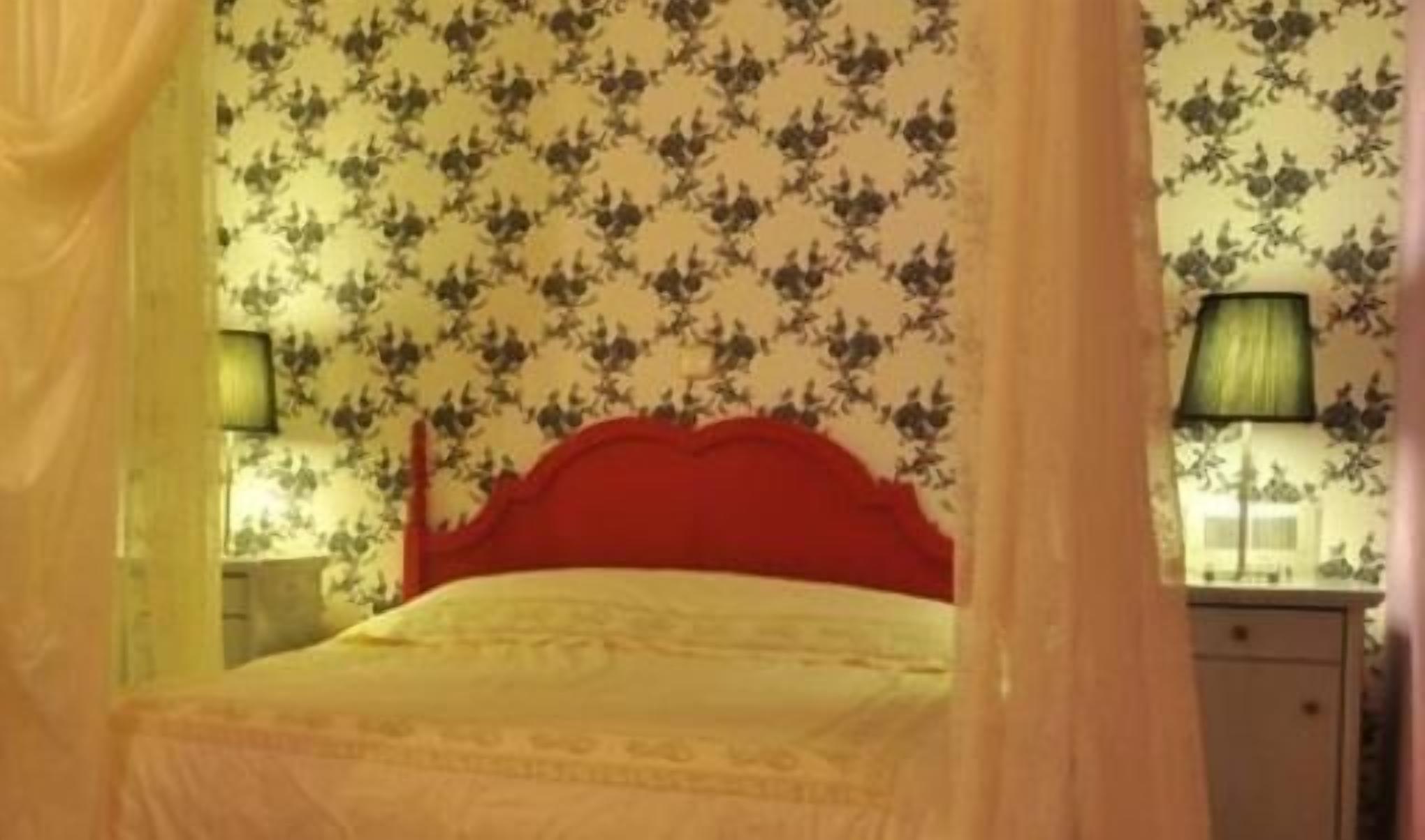 Un dormitorio con una cama, una mesita de noche y una lámpara.