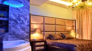 Une chambre moderne avec un grand lit, une table de chevet, une lampe et un jacuzzi.