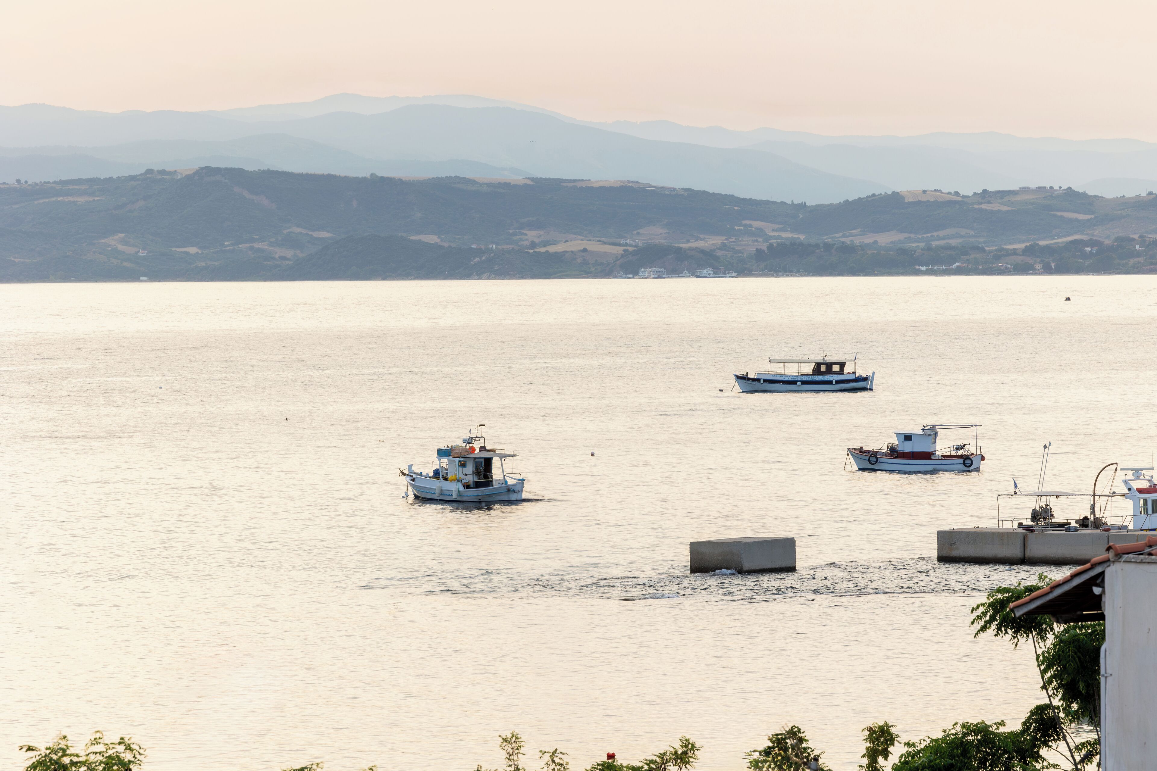 A calm body of water with several boats.