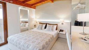 Een slaapkamer met een groot bed, nachtkastjes, een spiegel en een kledingrek.