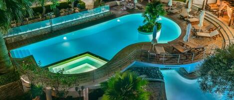 Una piscina al aire libre, sombrillas, sillones reclinables de piscina