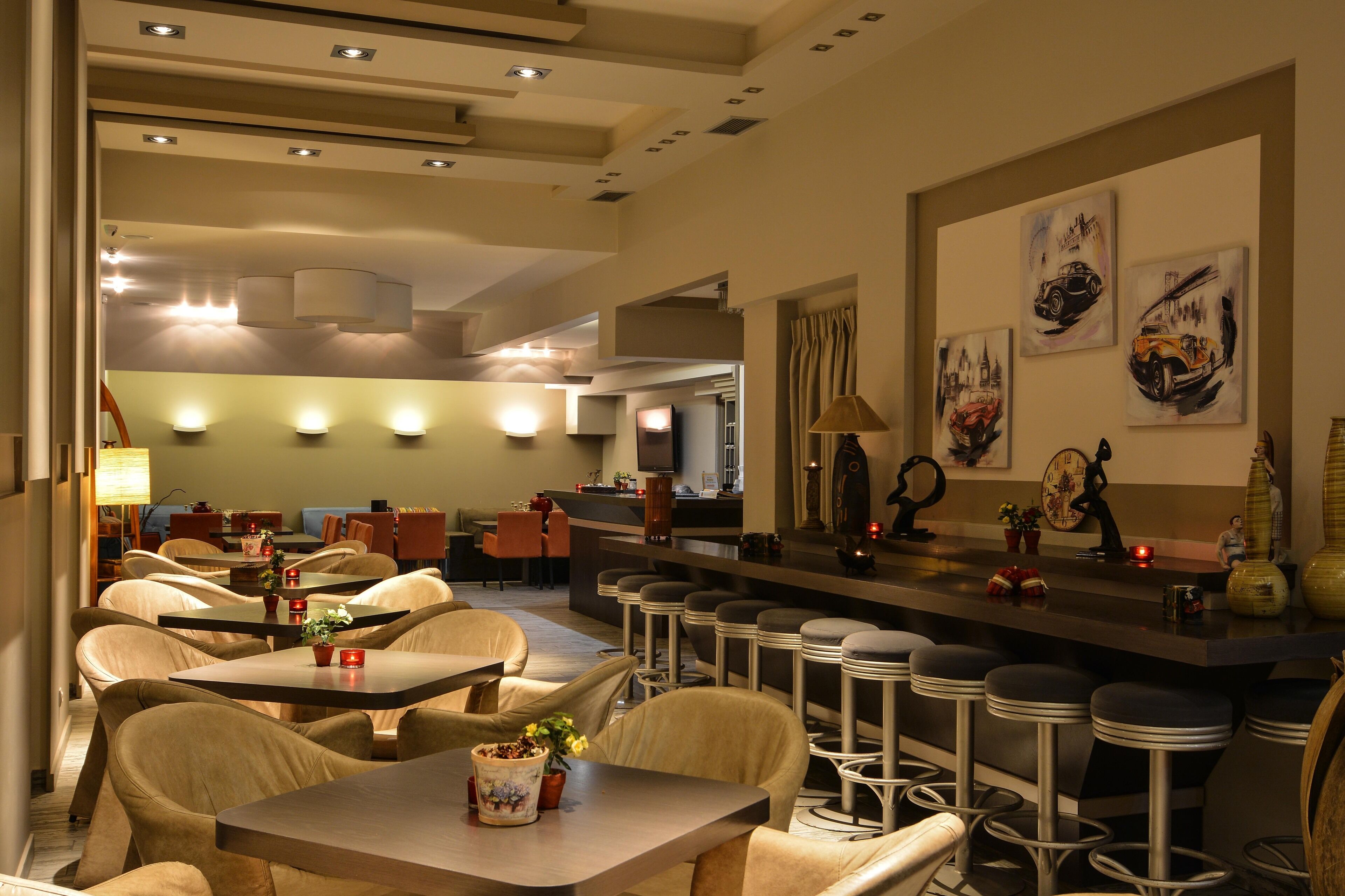 A modern restaurant with high tables and bar stools, ambient lighting, and artwork on the walls.