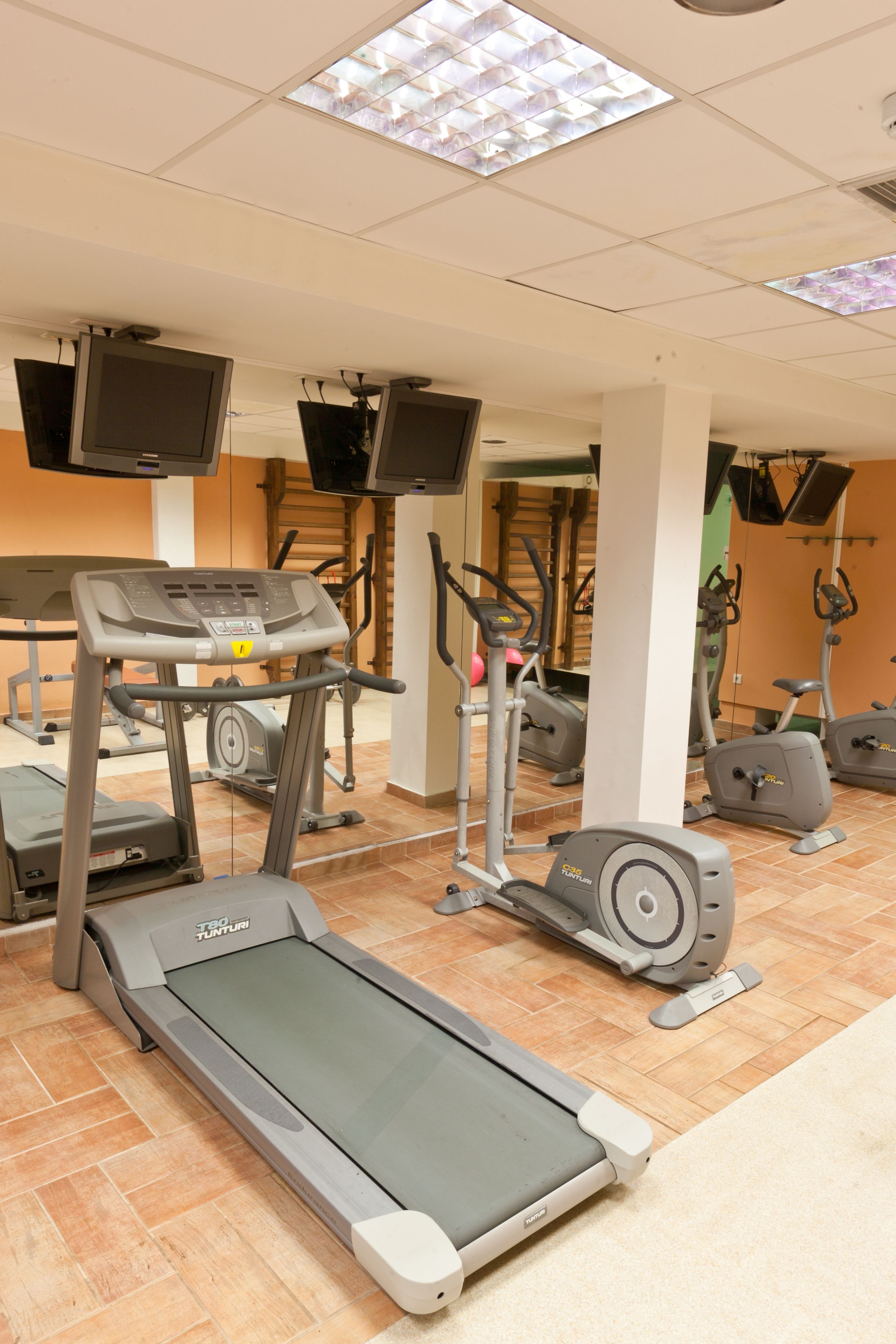 Een sportschool met loopbanden, crosstrainers en hometrainers.