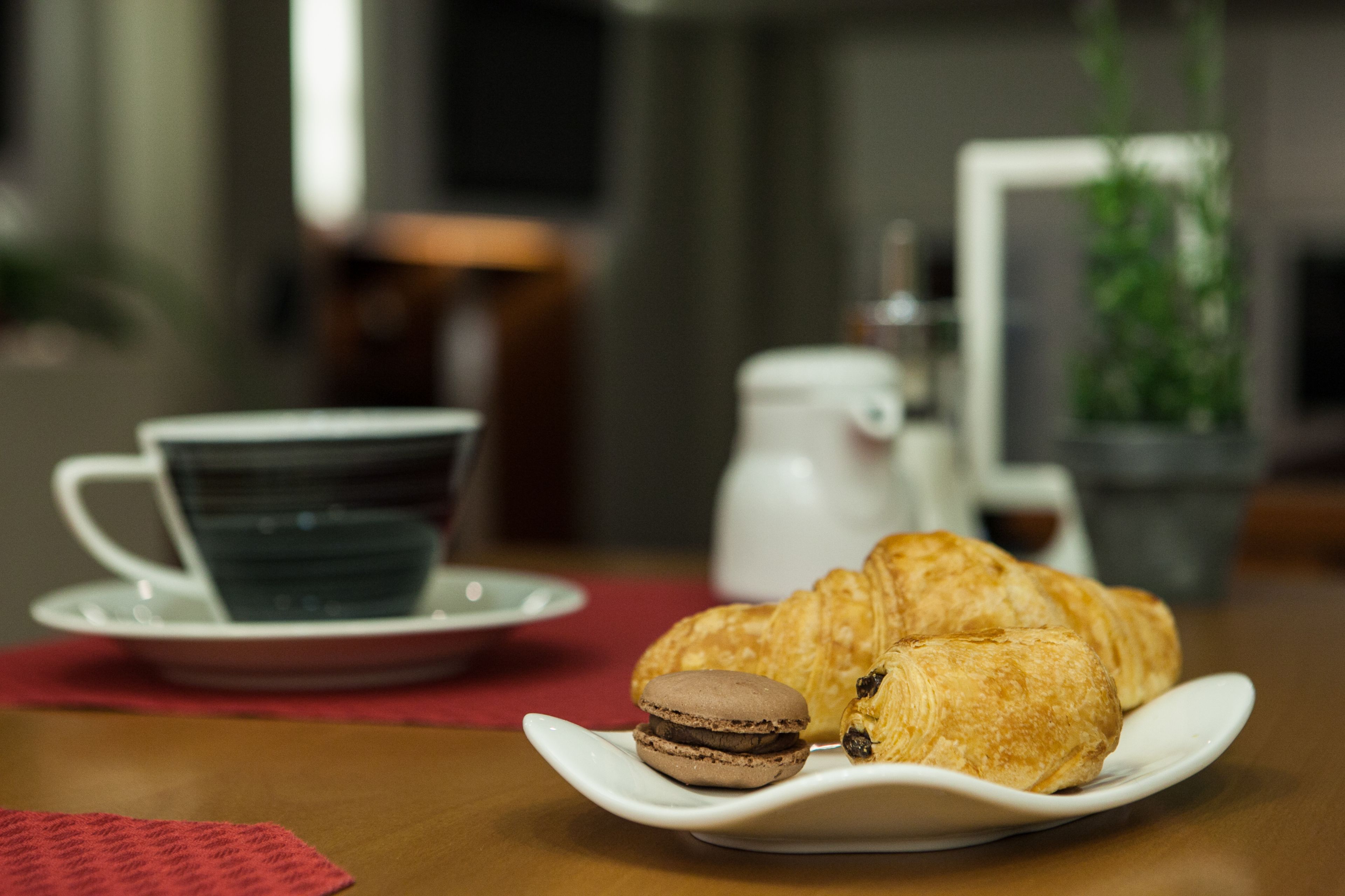 Ein Teller mit Croissants und einem Keks auf einem Tisch.