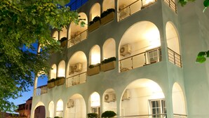 Een hotel met meerdere verdiepingen, boogvormige balkons en terrassen.