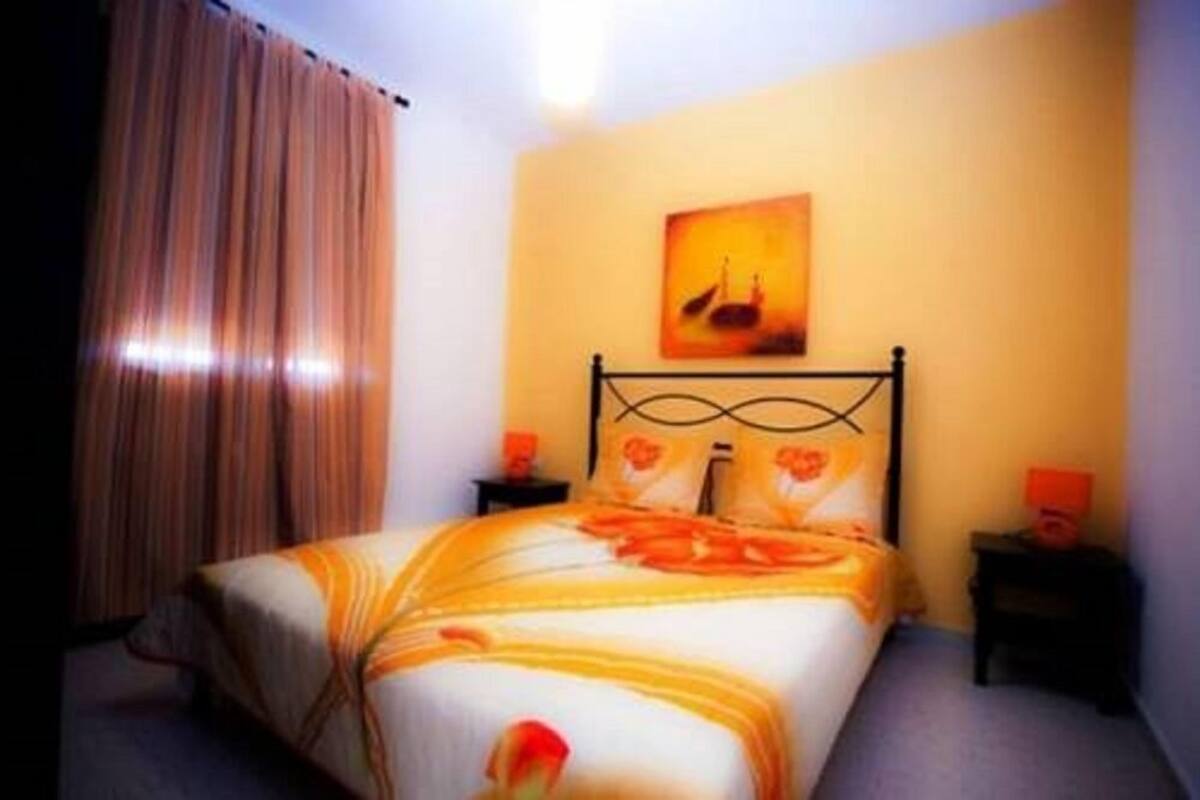 Ein Hotelzimmer mit einem Bett, einem Bild an der Wand und zwei Nachttischen.