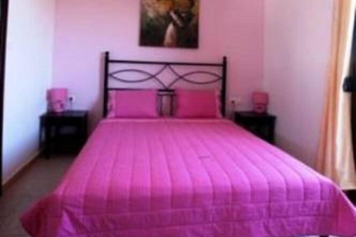 Ein Schlafzimmer mit einem großen Bett, einem Bild an der Wand und zwei Nachttischen.