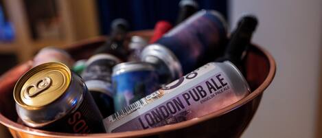 Un cuenco con una lata de Sol, una botella de London Pub Ale y otros artículos.