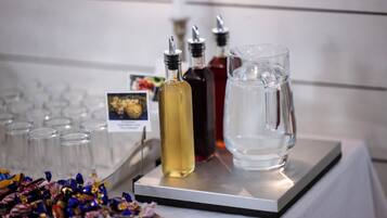 Una mesa con varias botellas, una jarra y una bandeja de dulces variados.