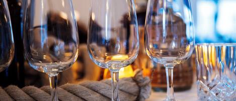 Three empty wine glasses on a table with a rope and a crystal decanter in the background.