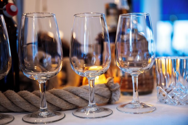 Three empty wine glasses on a table with a rope and a crystal decanter in the background. - Port Hotel (Karlshamn)