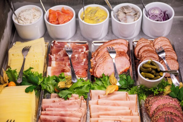 A buffet with various meats, cheeses, and condiments. - Port Hotel (Karlshamn)