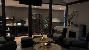 Uma sala de estar moderna com televisão de tela plana, assentos confortáveis e lareira.