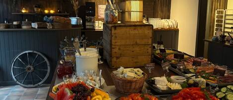 A buffet with various food items including fruits, cheeses, and meats.