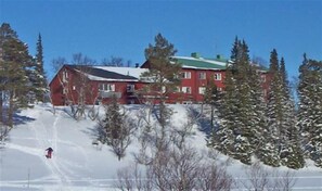 A red building with a green roof surrounded by snow-covered trees. - Storliens Fjällgård  - Hostel (Storlien)
